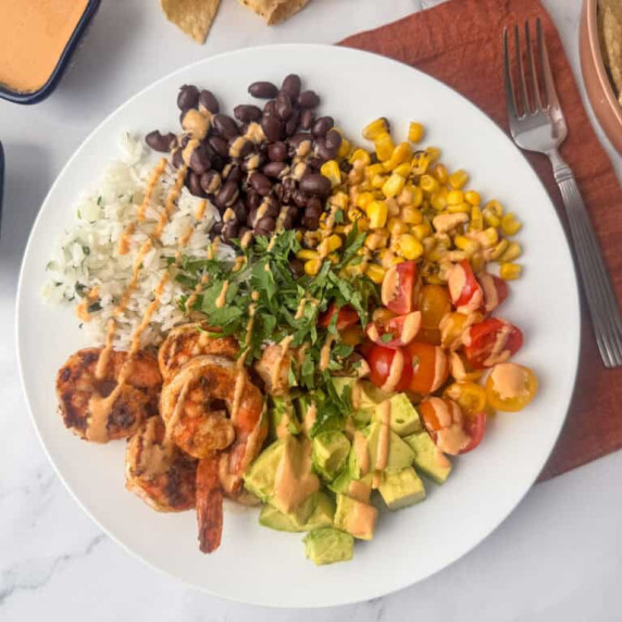 Overhead photo of shrimp burrito bowl made with seasoned shrimp, rice, beans and veggies