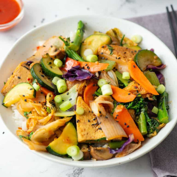 Over head photo of a plate with Kimchi Tofu Stir Fry with Vegetables over rice 