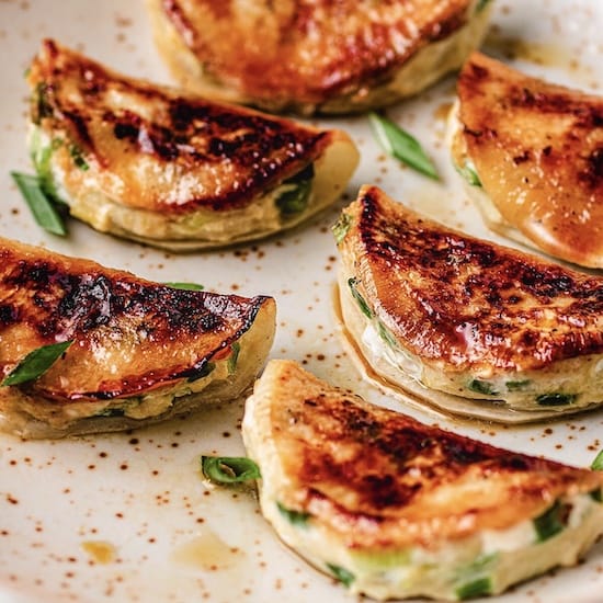 Potstickers on a white plate on a countertop