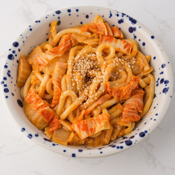 Kimchi udon with kimchi in a white bowl with blue dots