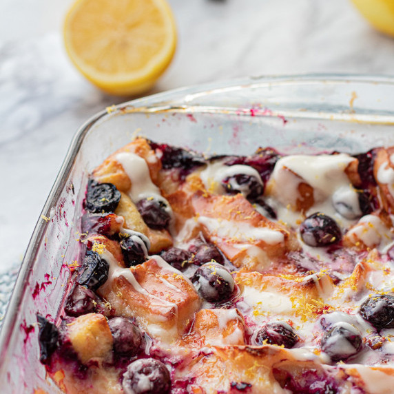 Baked lemon blueberry bread pudding in glass pan. 