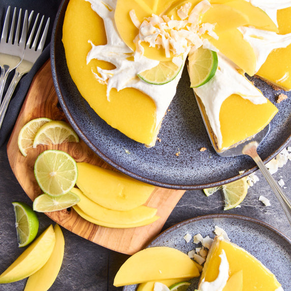 Mango White Chocolate Cheesecake with Protein on a dark blue plate, topped with Mango coulis
