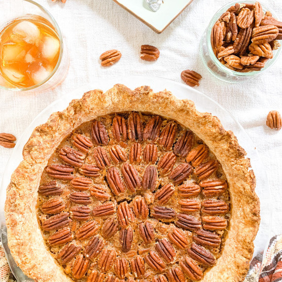 maple bourbon pecan pie with pecans and bourbon in the top corners
