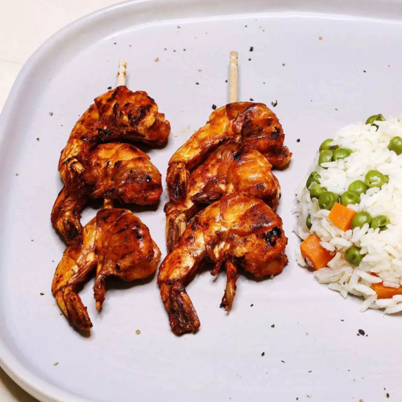 Mexican shrimp skewers served with rice in a plate