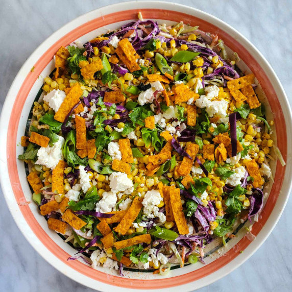 A colourful assortment of vegetables in a pink rimmed bowl.
