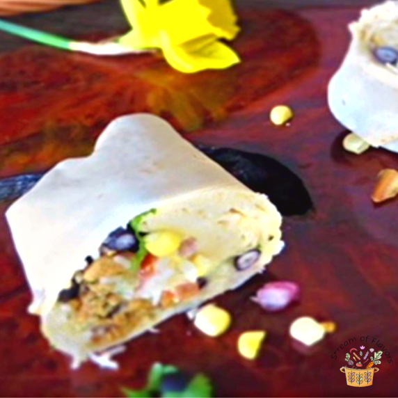 Mini Chicken Burritos with corn, beans, and chicken on a wooden board