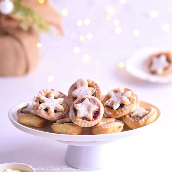 Bright airy image of mini mince pies, seasonal toppers & fairy lights