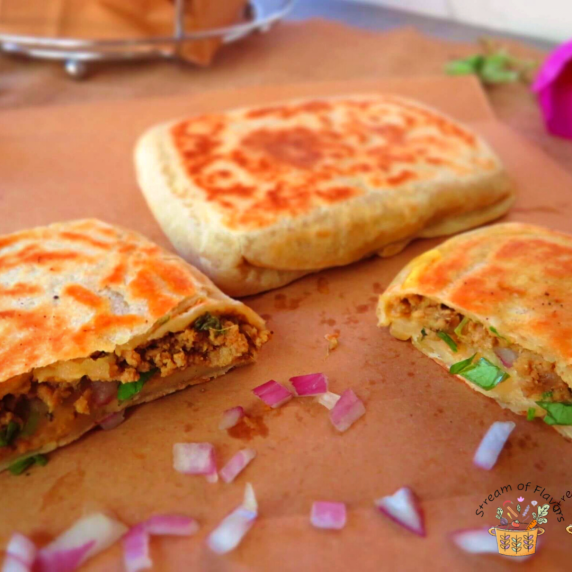 Meat stuffed crepe on brown board