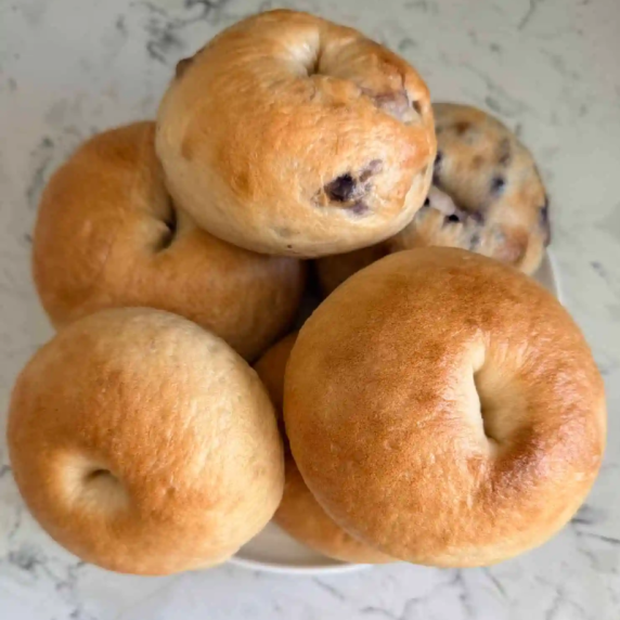 Homemade sourdough bagels with golden crust on cooling rack