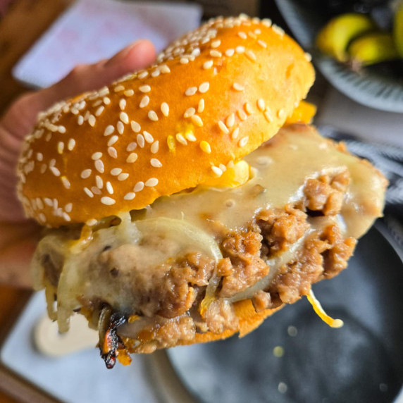 Two cheesy vegetarian burger patties between golden brioche buns.