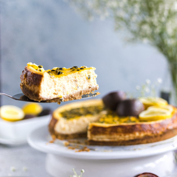 Lemon passion fruit cheesecake with a blue background. 