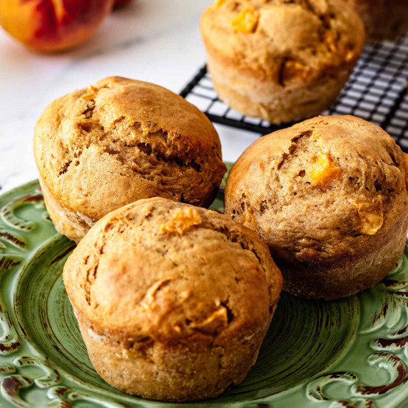 Three peach muffins on a green plate
