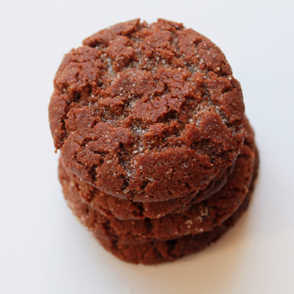 Stack of homemade peanut butter cookies with a cracked, sugar-dusted surface on a white background.