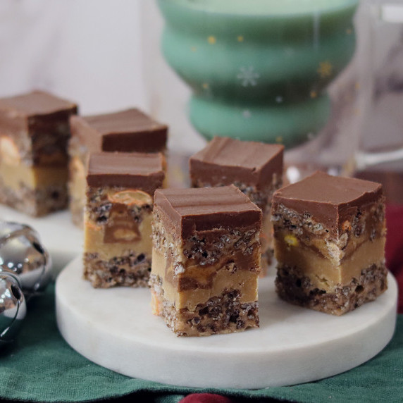 Peanut butter cup Rice Krispie treats on a holiday plate against a white background.