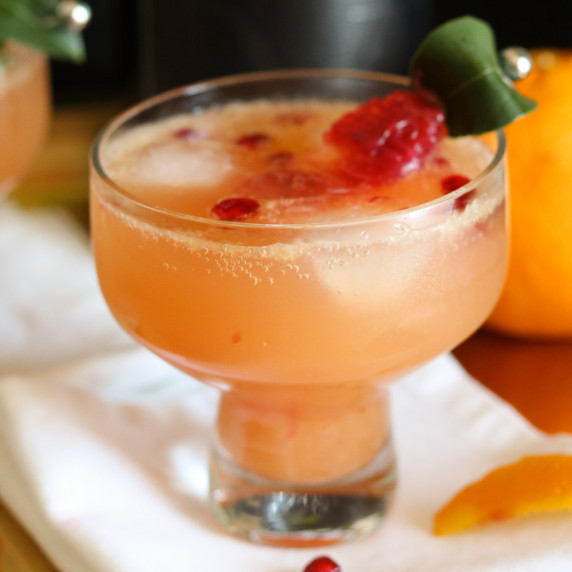 Pomegranate blood orange cocktail in coupe glass with garnish