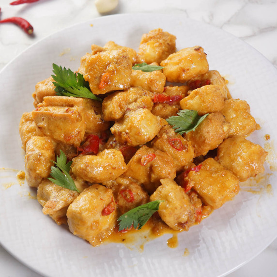 Crispy salted egg tofu made with tofu cubes coated in a savory salted egg yolk on a white plate