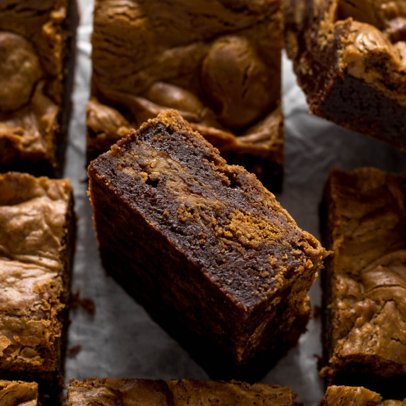 Biscoff brownie on its side showing the biscuits and swirl.