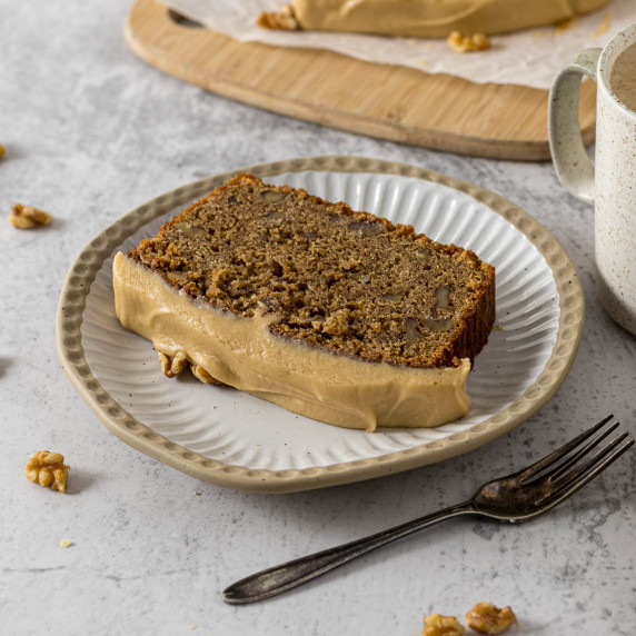 Slice of coffee walnut loaf on a plate.