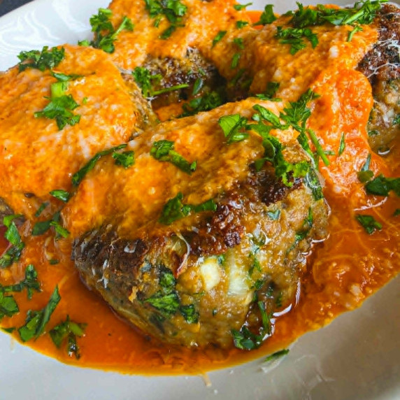 Golden meatballs smothered in red sauce, pecorino and green herbs.