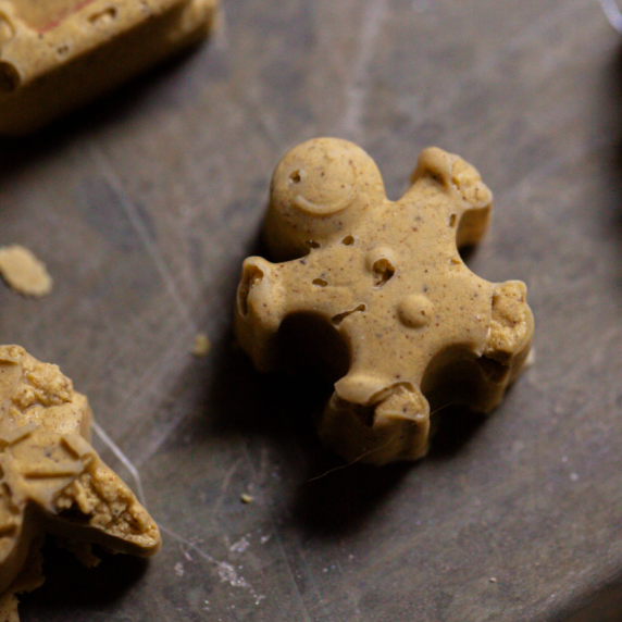 a gingerbread man gingerbread fudge smiling on a baking sheet 