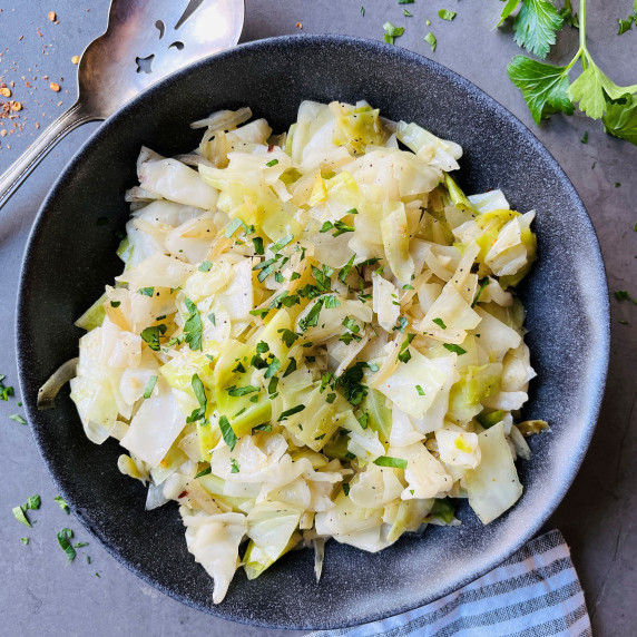 Cooked chopped cabbage in a gray bowl on a gray countertop.