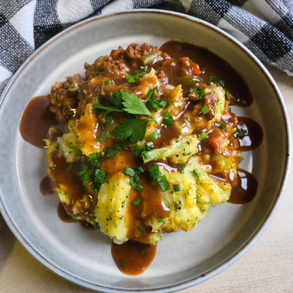 Golden mash and shep's pie filling smothered in brown gravy and green herbs.