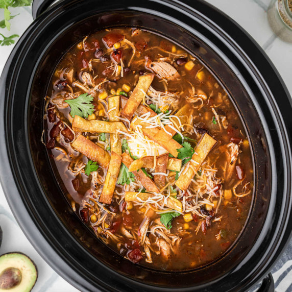 Close up overhead view of a slow cooker with chicken tortilla soup.