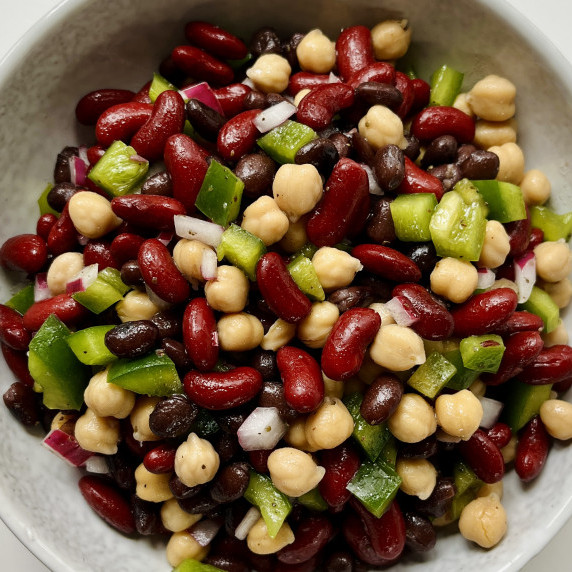 Three bean salad with green pepper and onion in a gray bowl.