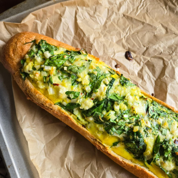 Golden baguette stuffed with a yellow egg & green spinach mixture.
