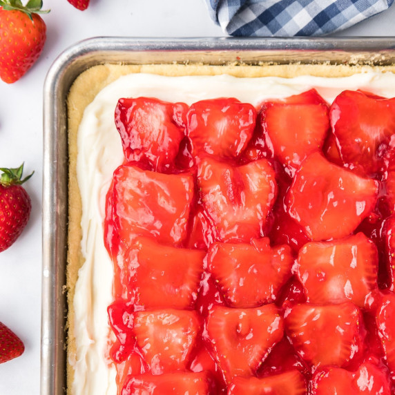Strawberry pizza with a cookie dough, frosting and glazed strawberries from above.