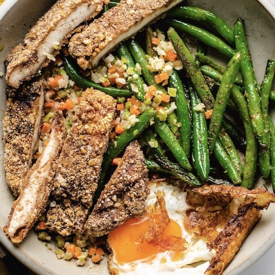 Fried chicken cutlets and green beans in a stoneware bowl