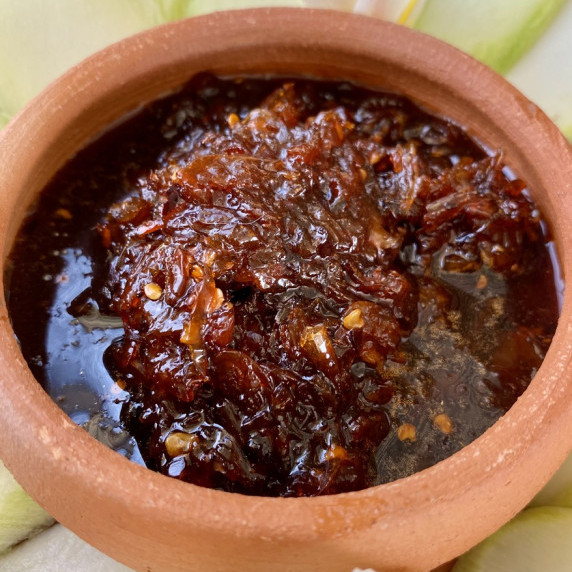 Thai mango dipping sauce in a clay sauce cup.