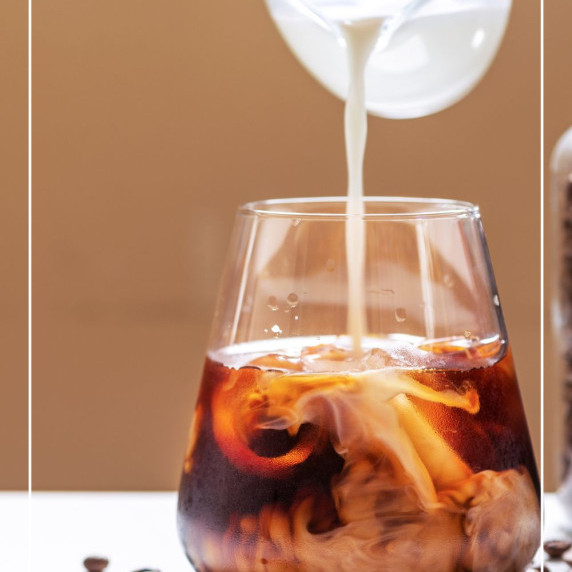 pouring cream into cold brew coffee