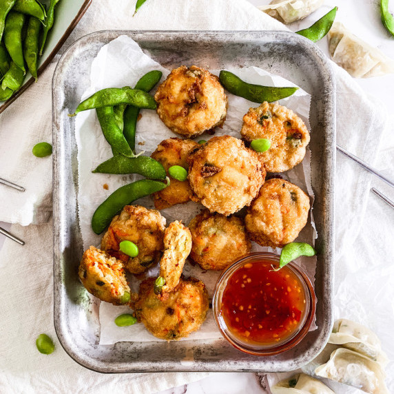 tray of tofu edamame nuggets with thai chili sauce on a white linen napkin