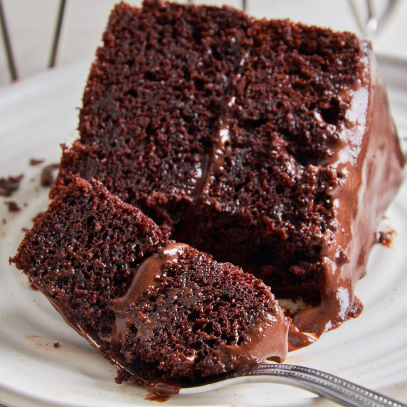 Moist Protein Chocolate Cake with Sourdough on a white plate, a piece of it on a fork