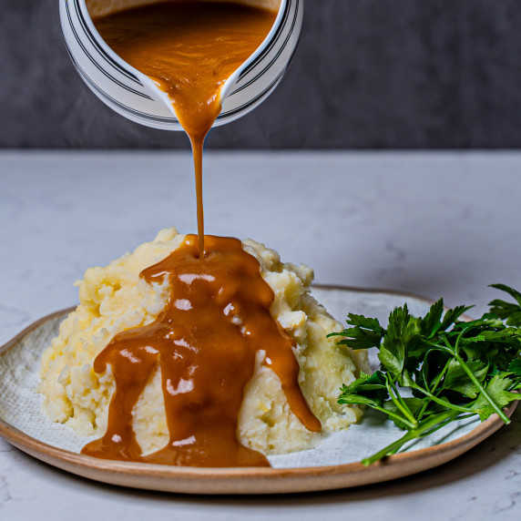 silky smooth brown gravy poured onto mashed potatoes