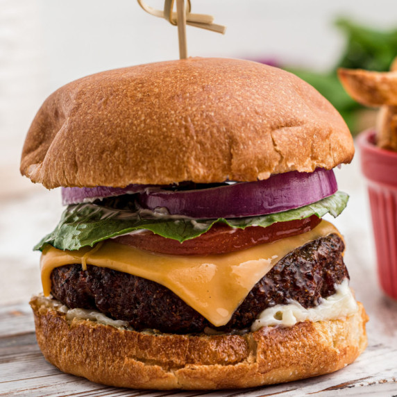 a dressed venison burger with some melted cheese
