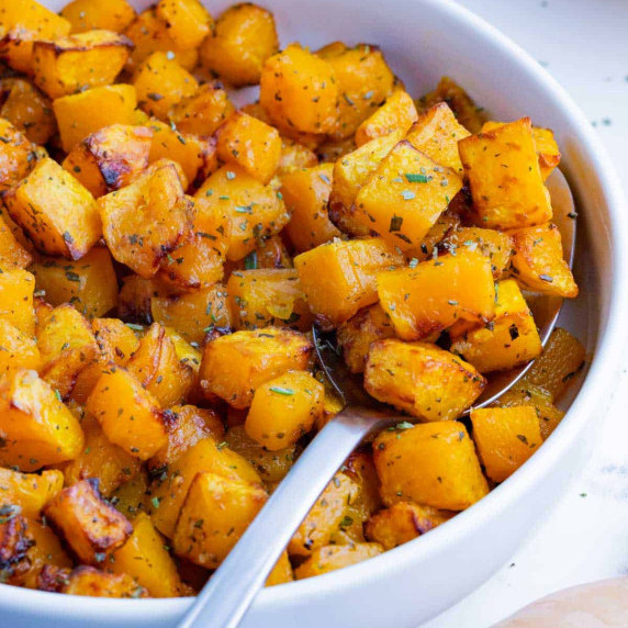 Air Fryer Butternut Squash RECIPE inside a white bowl and a metal spoon.
