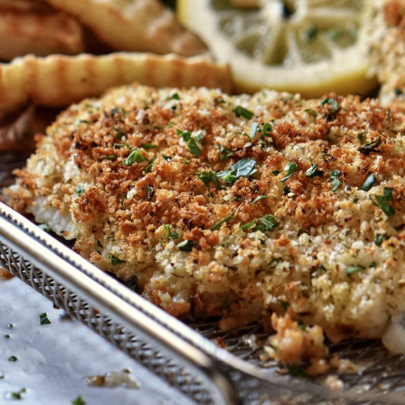 Panko encrusted cod on an air fryer basket. 