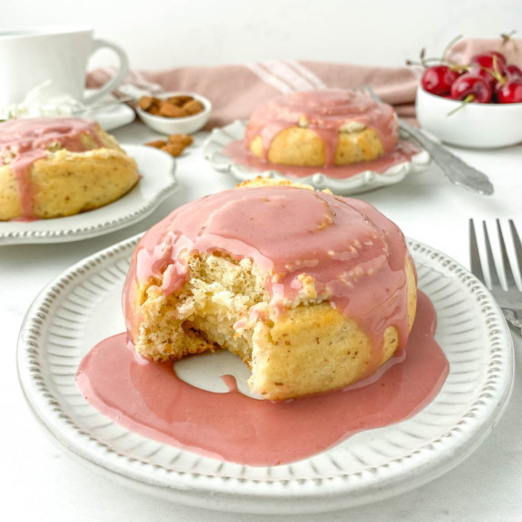 Almond Roll with Cherry Glaze on a white plate with a bite missing.