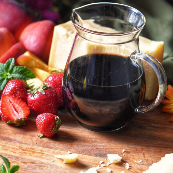 Balsamic vinegar glaze next to strawberries.