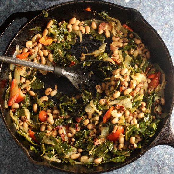 black-eyed peas with collard greens in a black skillet