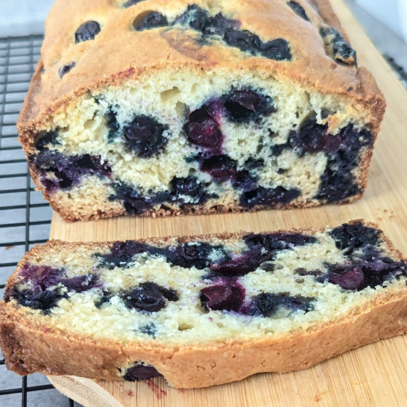 Blueberry muffin bread sliced open on a cutting board.