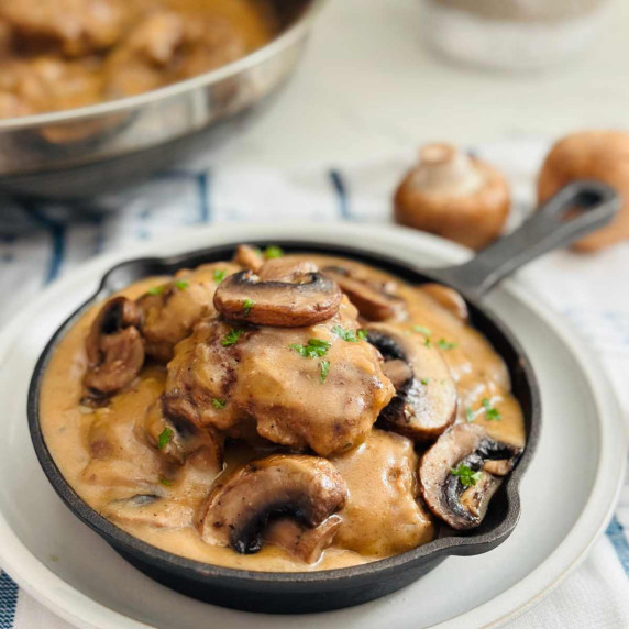 burger steak with mushroom sauce on a cast iron pan