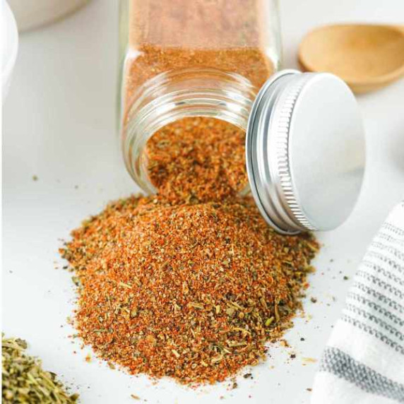 spice jar with spilled pile of cajun spice blend.