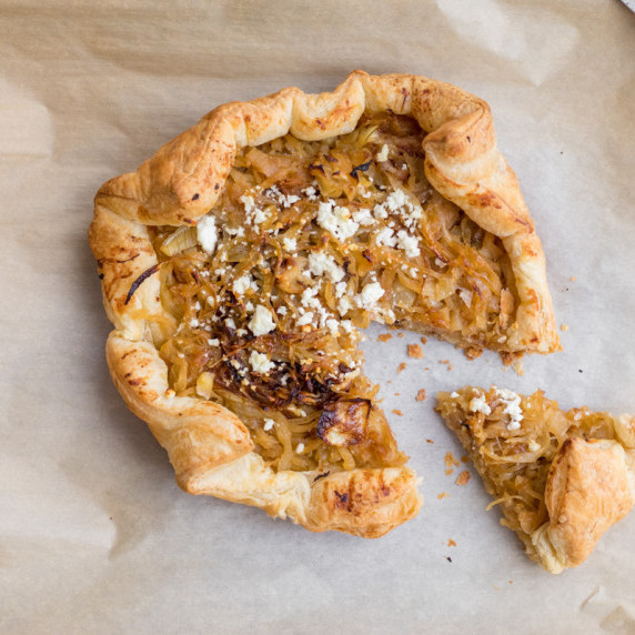 caramelized onion and goat cheese tart with a slice pulled out of it