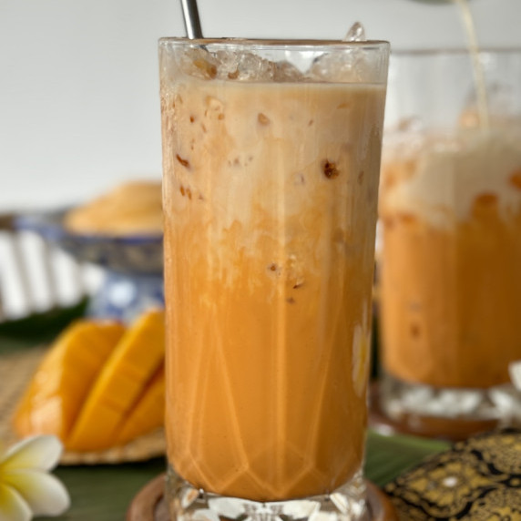 Thai tea, cha yen, served in a tall glass.