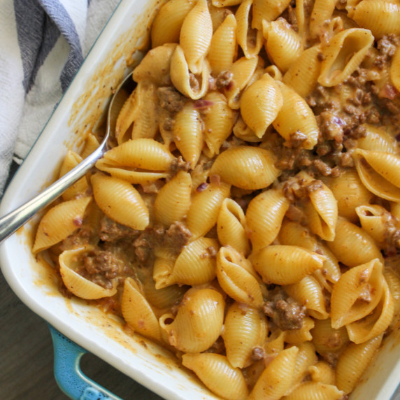 A dish of oven baked cheeseburger mac and cheese with a serving spoon