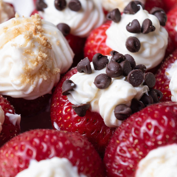 Fresh strawberries fill with sweetened cream cheese and topped with chocolate chips.