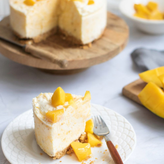 A slice of the No Bake Mango Cheesecake in a plate on the counter